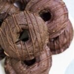 healthy chocolate donuts on a white plate with a blue background