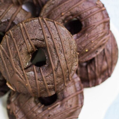 healthy chocolate donuts on a white plate with a blue background