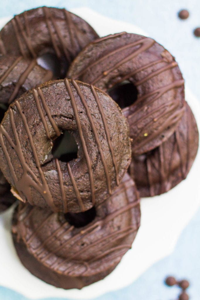 healthy chocolate donuts on a white plate with a blue background