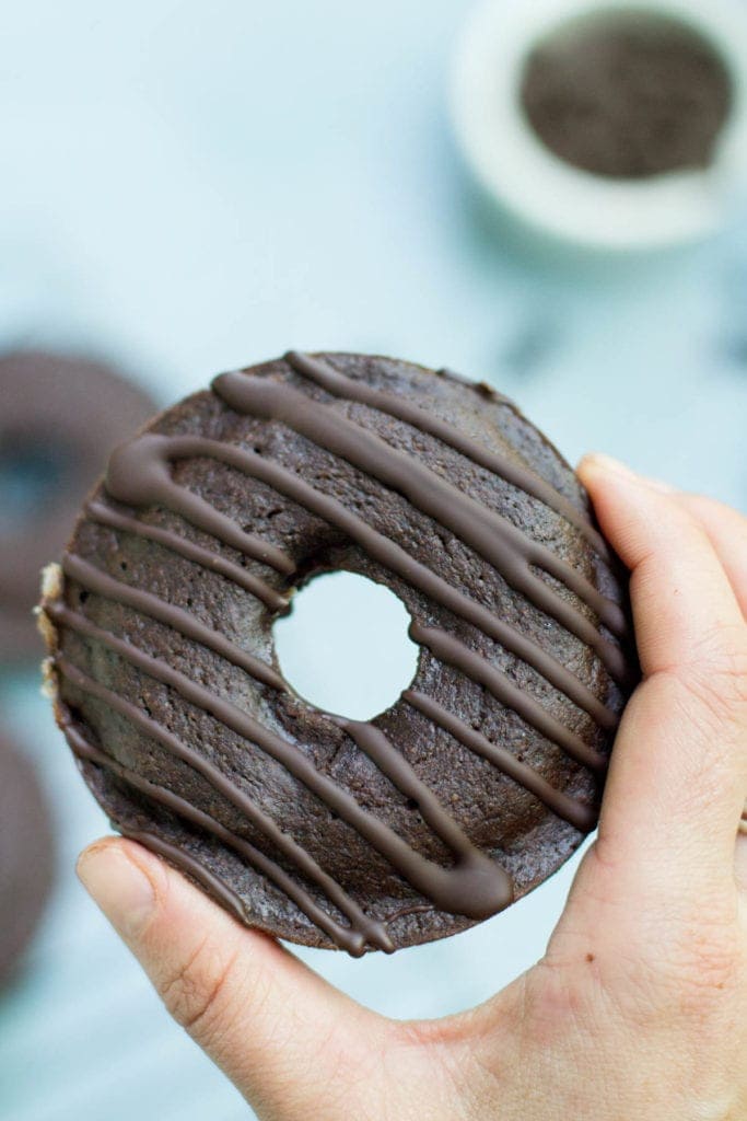 a hand holding up a healthy chocolate donut