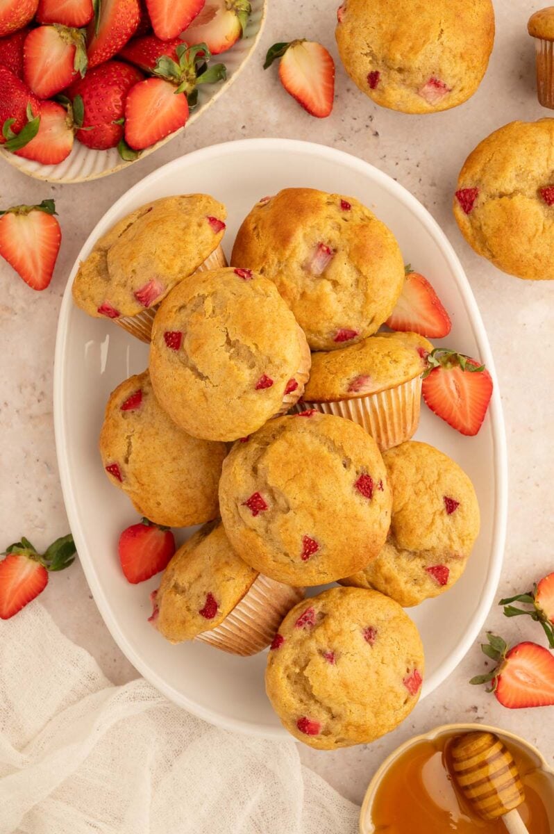 A pile of strawberry protein muffins on a white platter.