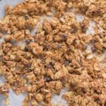 An overhead shot of peanut butter granola on a parchment lined baking sheet.