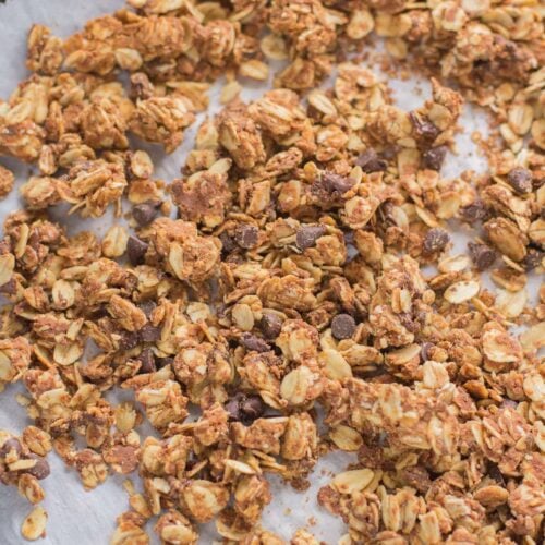 An overhead shot of peanut butter granola on a parchment lined baking sheet.