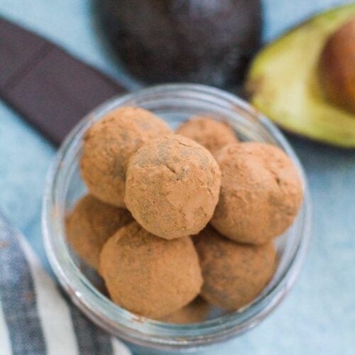 Healthy Chocolate Truffles in a small bowl on a blue background.
