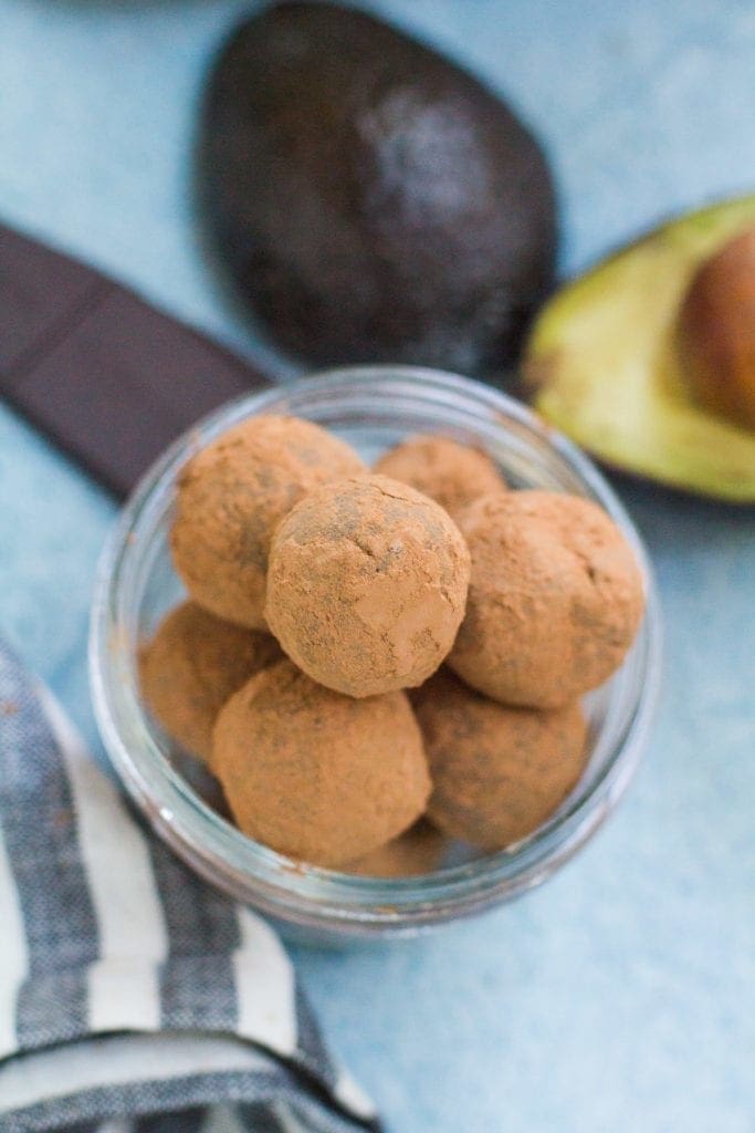 Healthy Chocolate Truffles in a small bowl on a blue background.