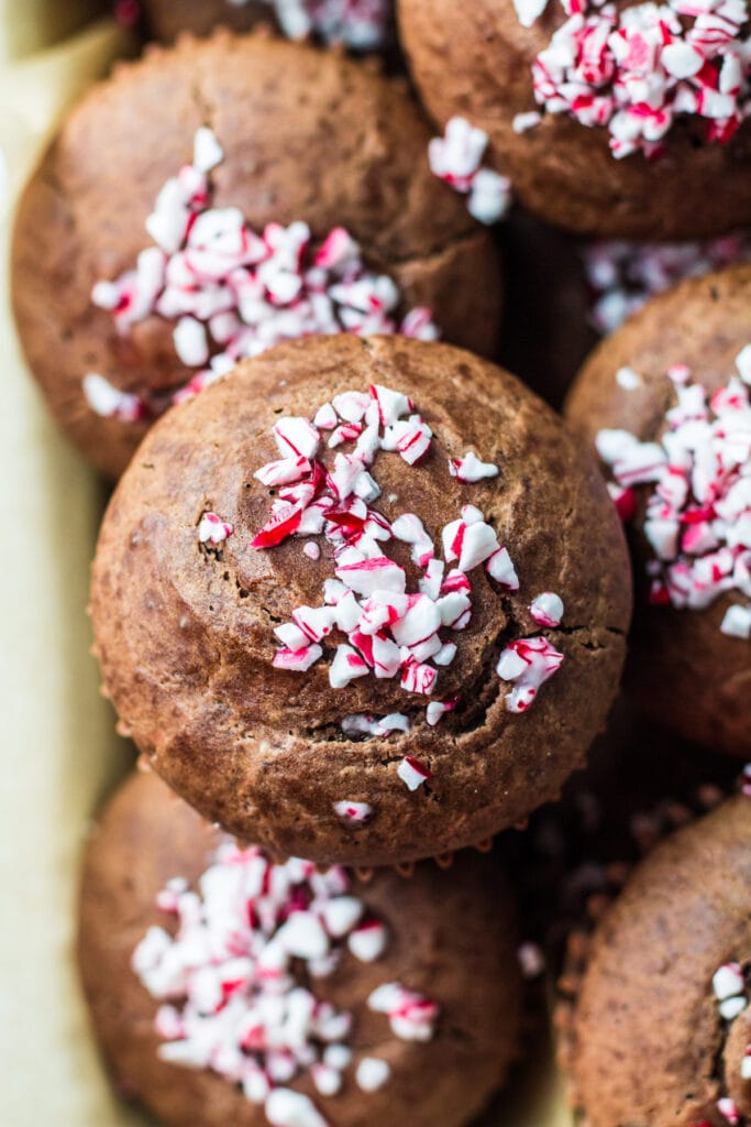 a close up of a chocolate mint muffin on a plate filled with muffins.