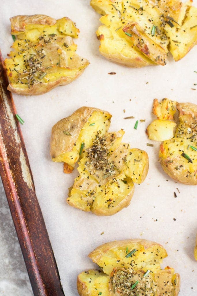 oven roasted smashed Potatoes on a parchment lined baking sheet
