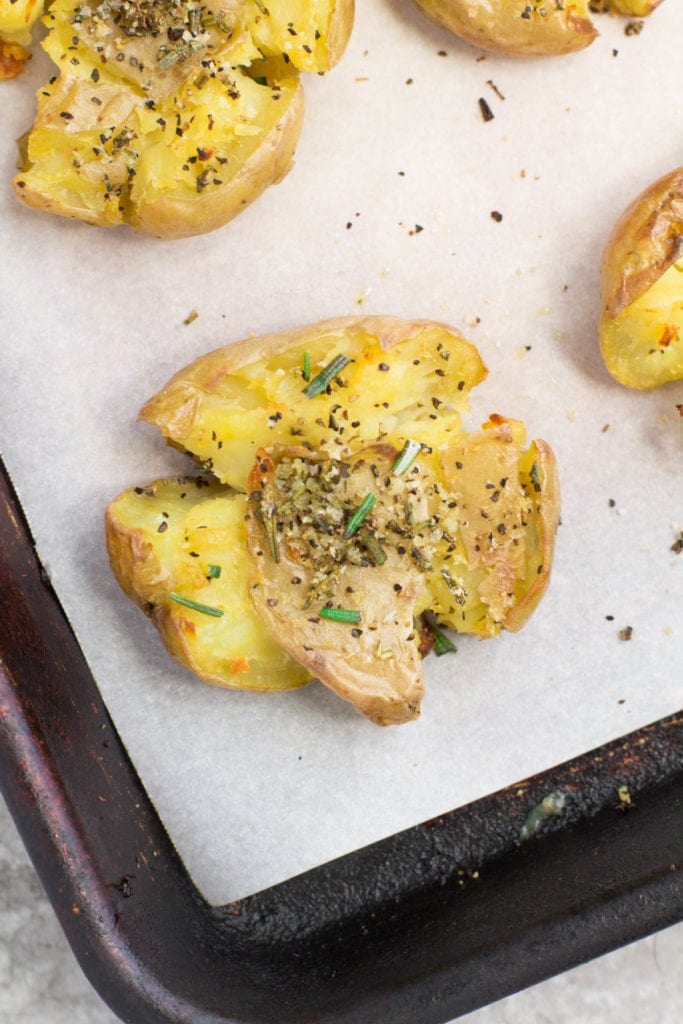the best Crispy Smashed Potatoes on a parchment lined baking sheet