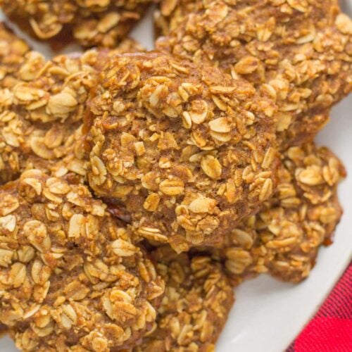A plate of gingerbread breakfast cookies with a red checked linen off to the side