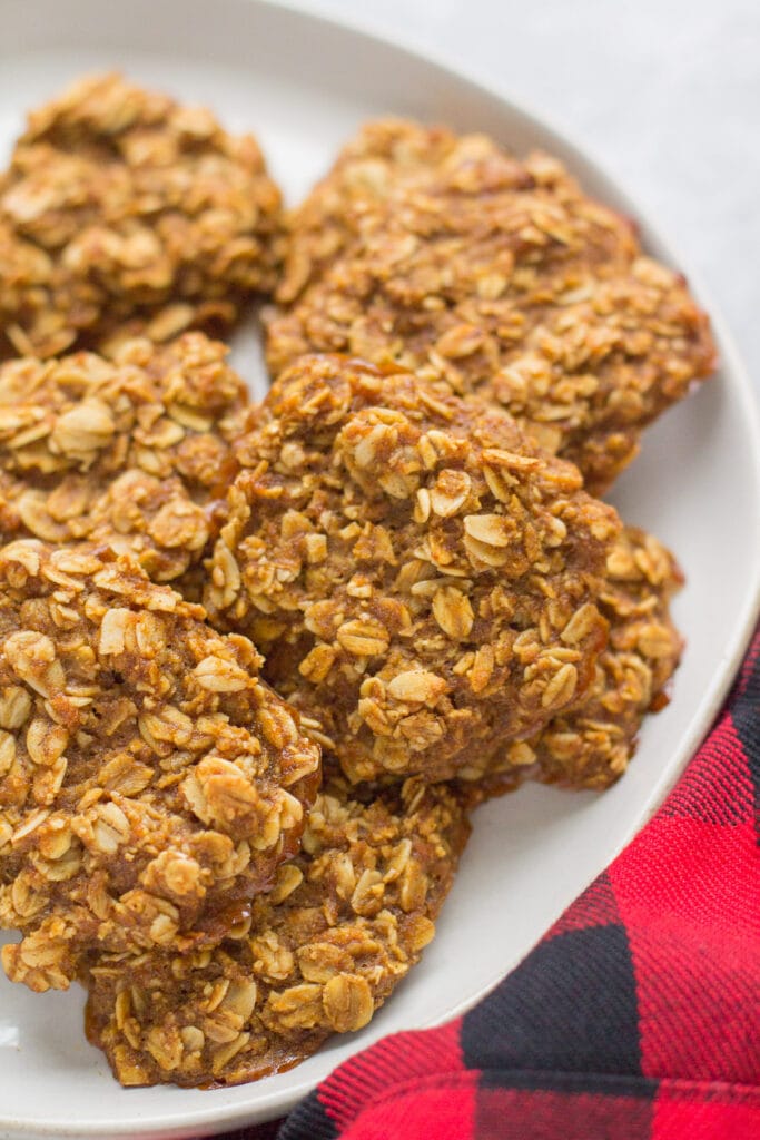 Gingerbread Breakfast Cookies on a white plate with a red checked linen off to the side. 