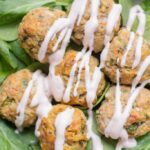 Healthy Buffalo turkey meatballs over a bed of spinach with a greek yogurt drizzle