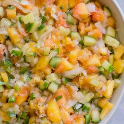 Healthy Peach Salsa in a white bowl on a grey background