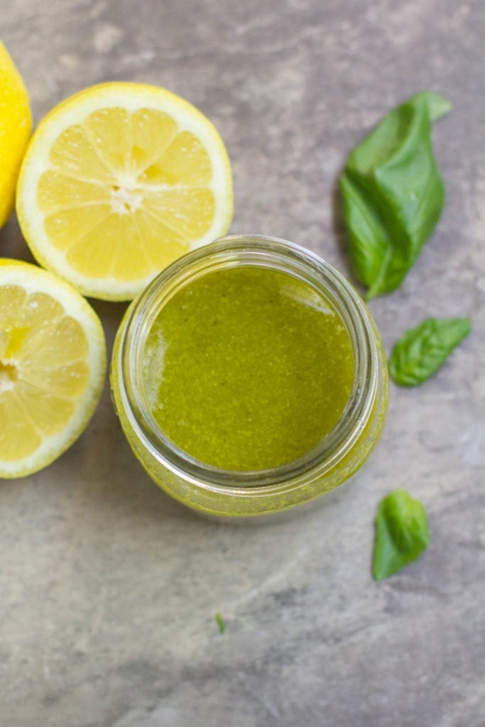 Overhead view of bright green salad dressing in a glass jar.