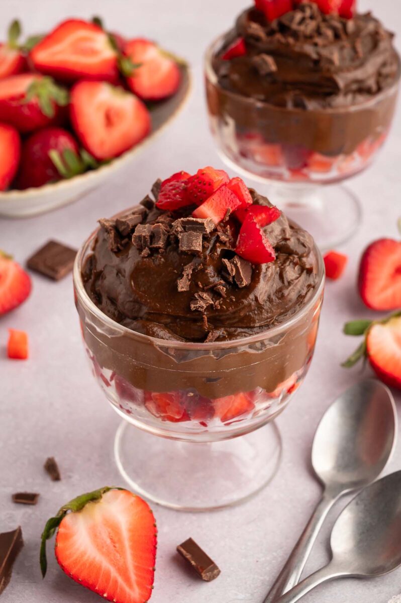 Healthy Chocolate Pudding in a clear serving dish topped with chopped strawberries.