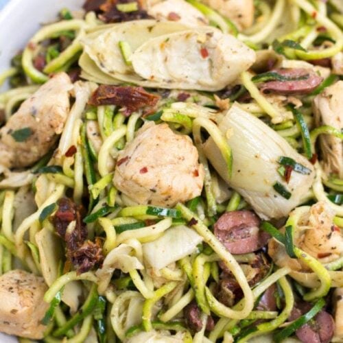 Whole30 Greek Chicken Zucchini Noodles in a white bowl on a blue background