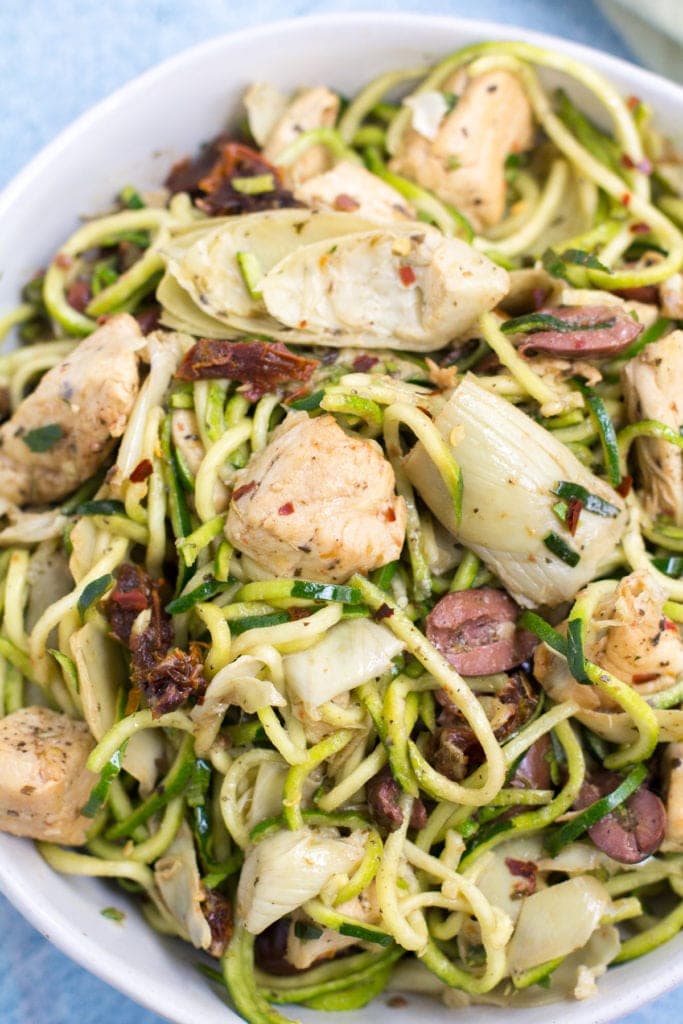 Whole30 Greek Chicken Zucchini Noodles in a white bowl on a blue background