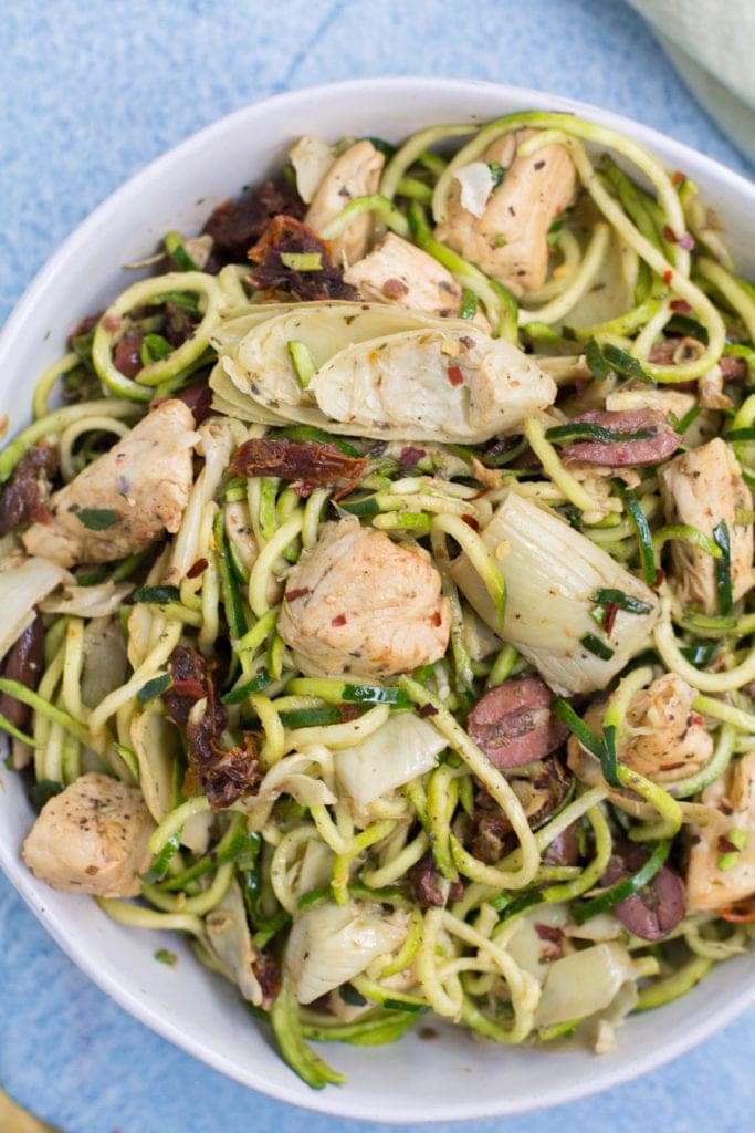 Whole30 Greek Chicken Zucchini Noodles in a white bowl. A close up shot showing the details of the dinner.