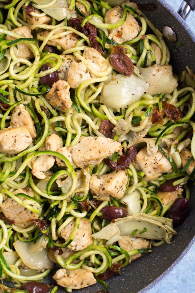 Whole30 Greek Chicken Zucchini Noodles in a black pan tossed together.