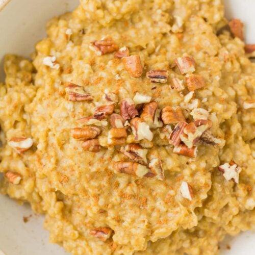 Slow Cooker Steel Cut Oats in a white bowl on a grey background with a blue linen to the side