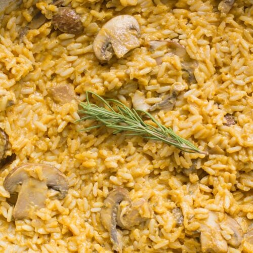 A close up of pumpkin mushroom risotto in a white pan
