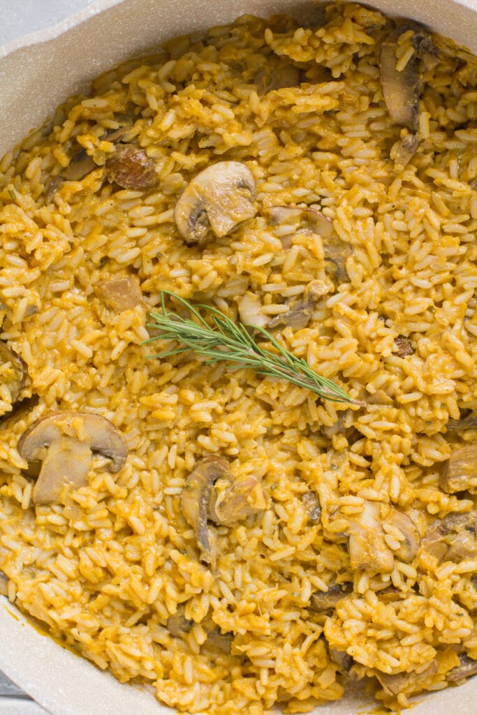 An overhead shot of pumpkin mushroom risotto in a white saute pan