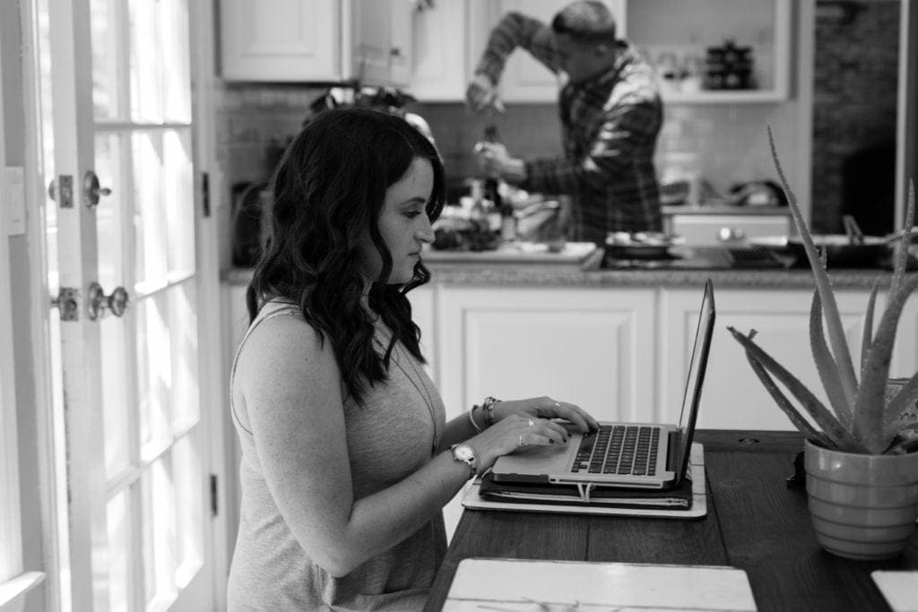A girl working at a laptop in a kitchen