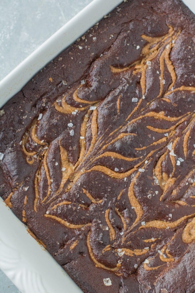 An overhead shot of almond butter brownies in a white baking dish.