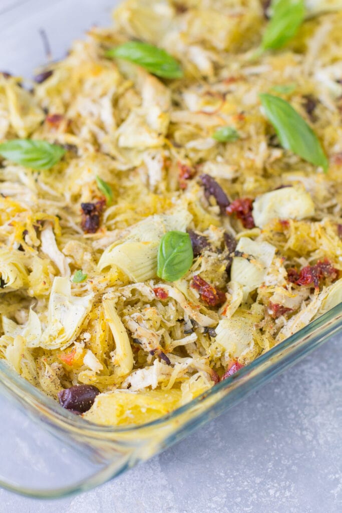 Greek Chicken Spaghetti Squash Bake in a glass dish on a grey background getting ready to go into the oven
