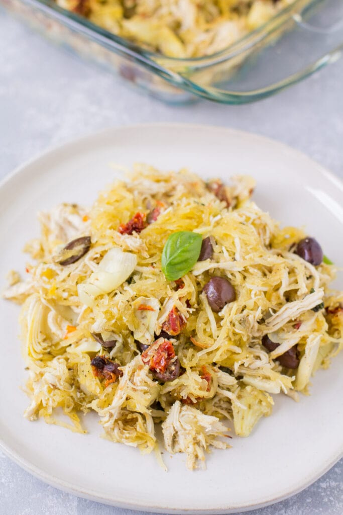 Spaghetti Squash Bake on a white plate with a glass baking dish behind it.