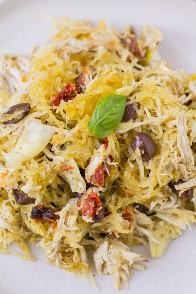 Greek spaghetti squash bake on a white plate on a grey background