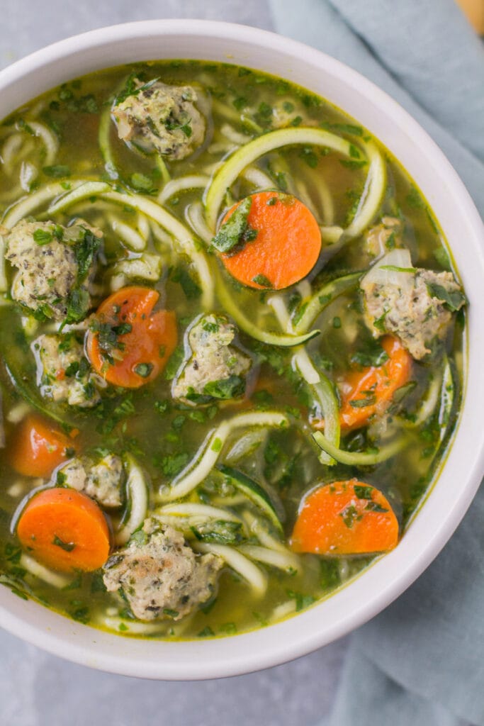 A close up of Healthy Italian Wedding Soup in a white bowl.