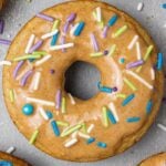A healthy protein donut, baked and decorated with nut butter glaze and colorful jimmies.
