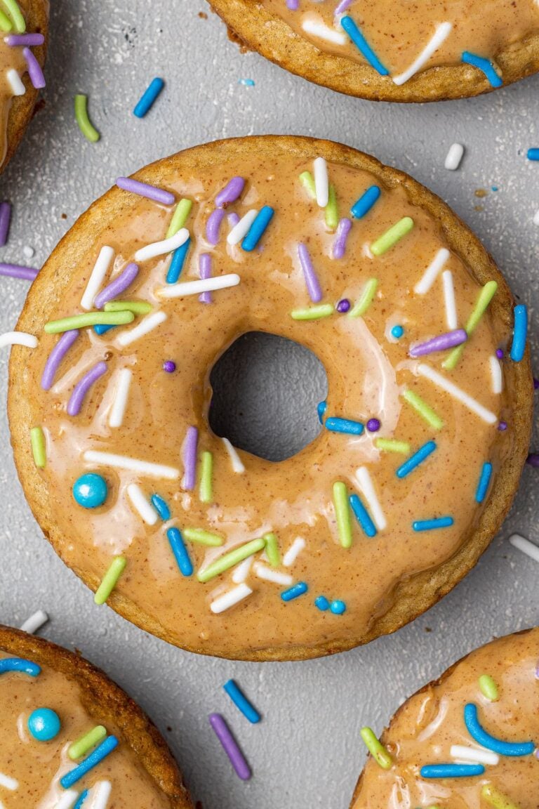 A healthy protein donut, baked and decorated with nut butter glaze and colorful jimmies.