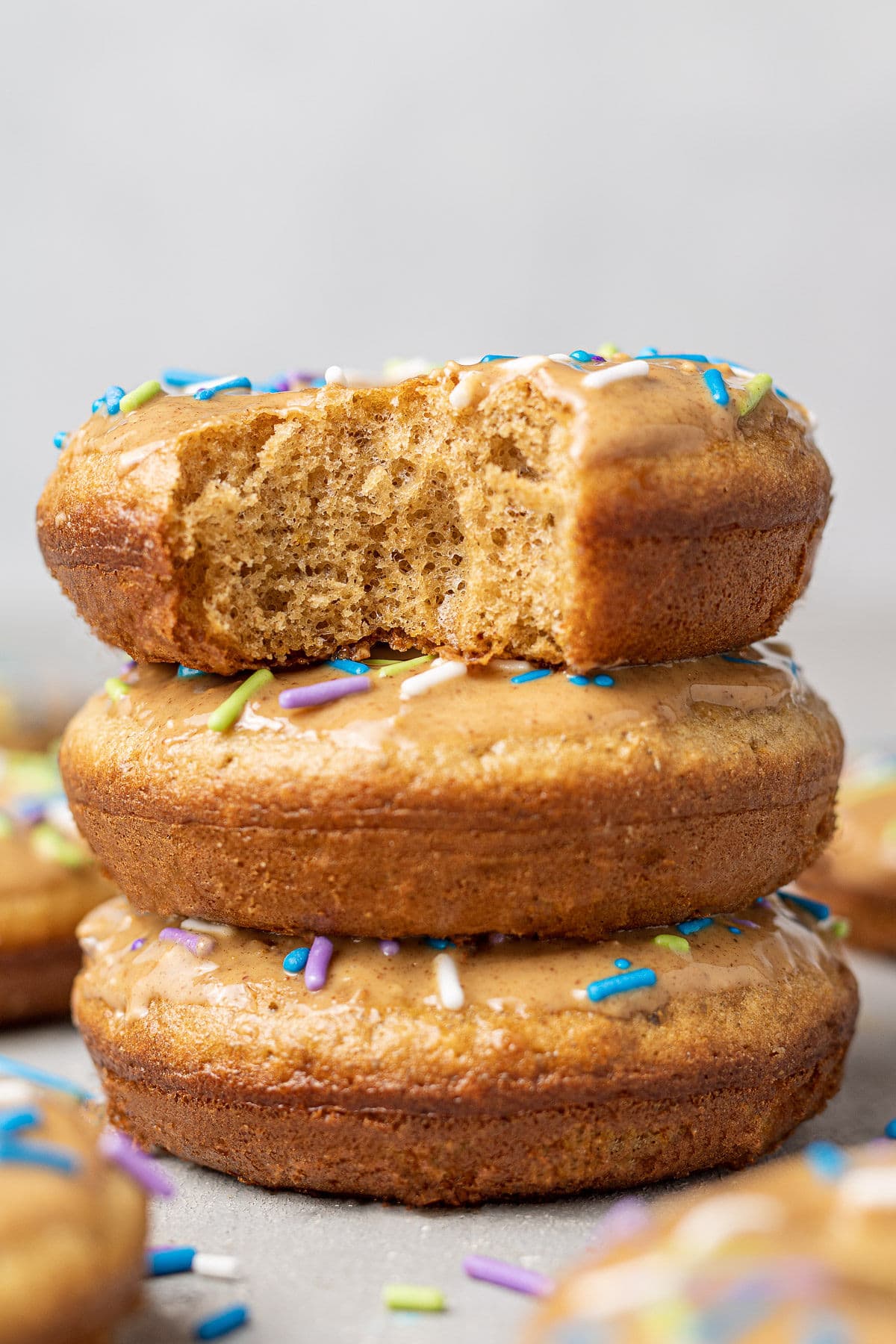 A close up of three homemade protein donuts stacked on top of one another.