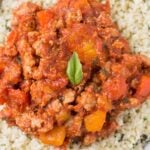 A close up of Healthy Unstuffed Peppers in a white bowl. Ground meat + peppers in a sauce over cauliflower rice.