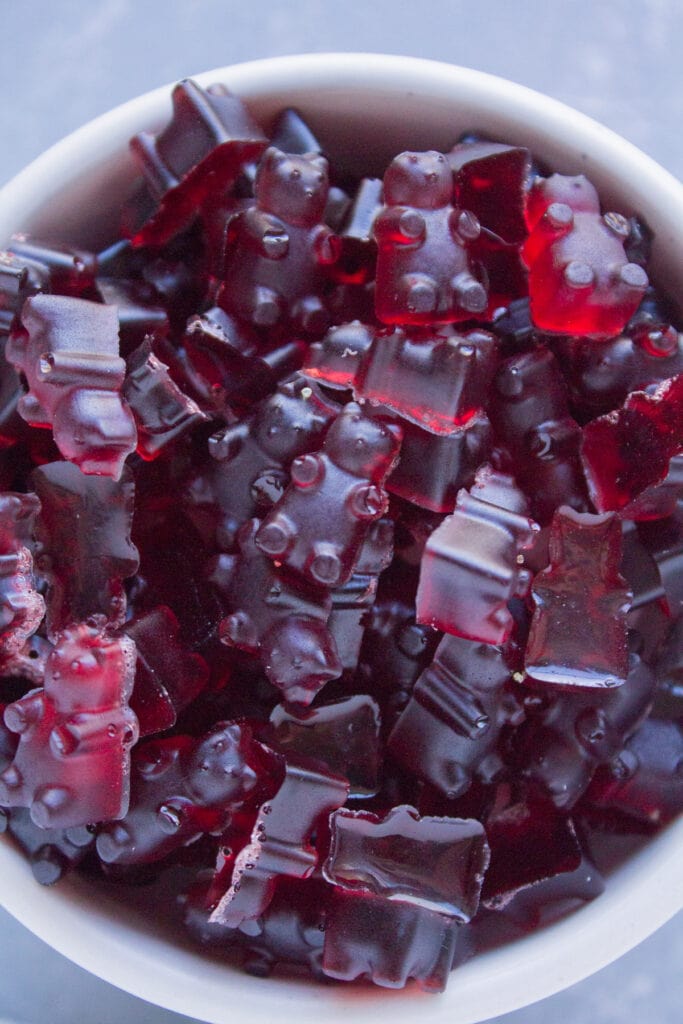 A closeup of homemade gummy bears on a grey background.