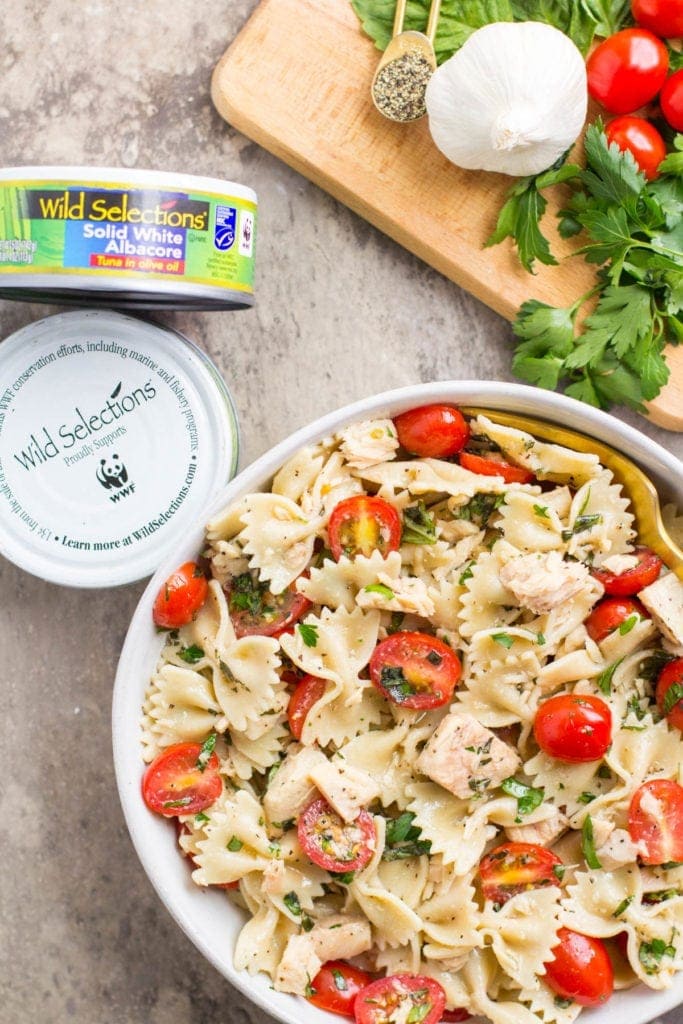 Healthy Tuna Pasta Salad in a bowl with a cutting board and canned tuna off to the side
