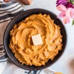 Maple Whipped Paleo Sweet Potatoes in a black bowl on a grey background