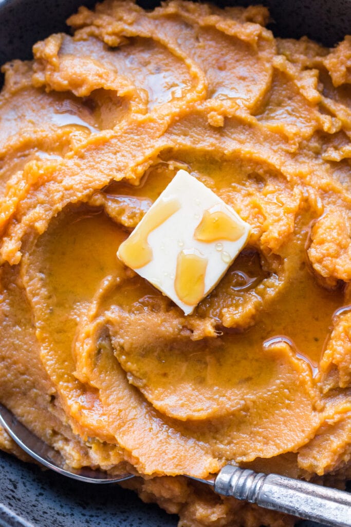 A close up of butter on top of mashed paleo sweet potatoes