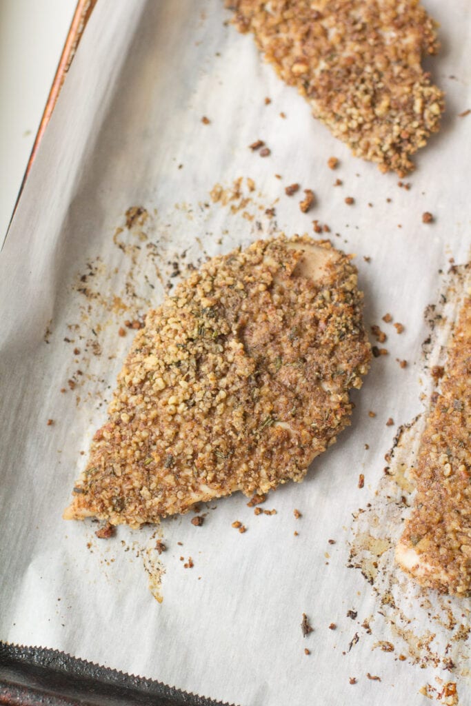 Pecan Crusted Chicken on a parchment lined baking sheet