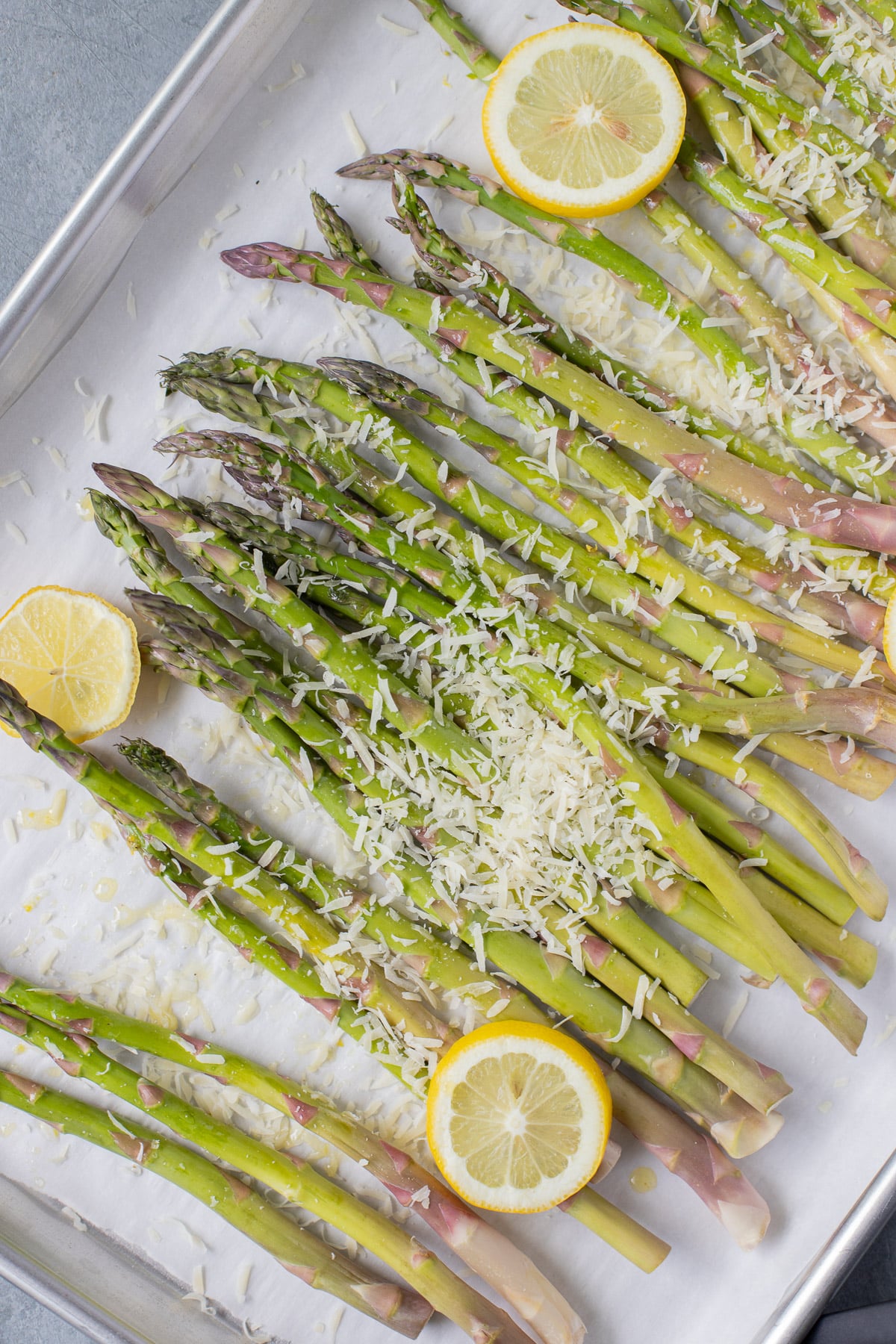 Lemon asparagus on a parchment lined baking sheet before being cooked
