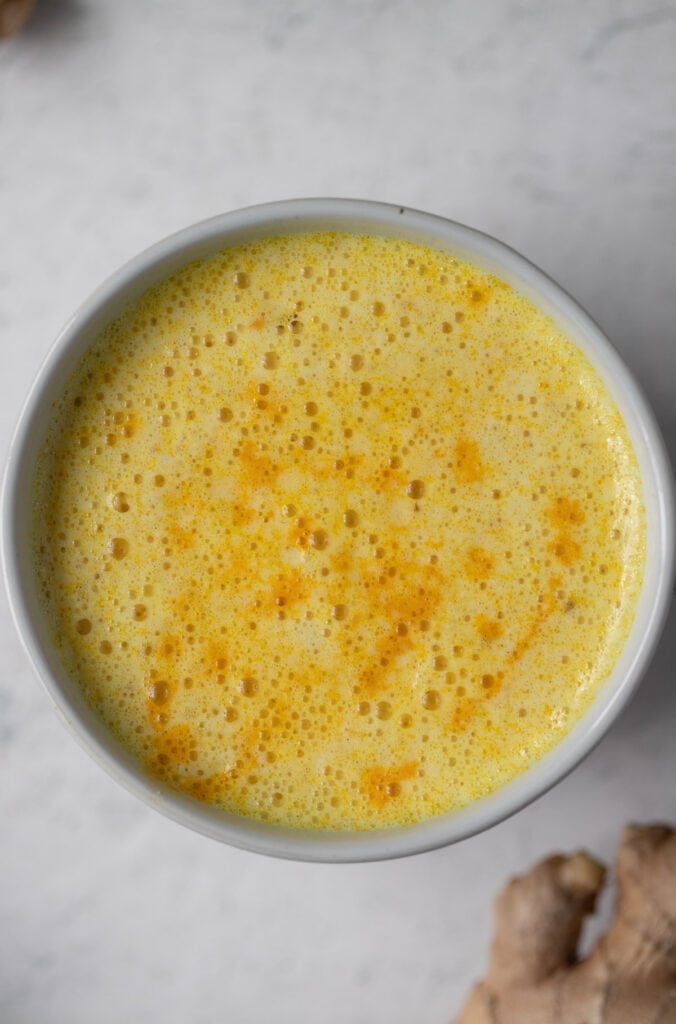 a close up of a vegan turmeric latte on a white background