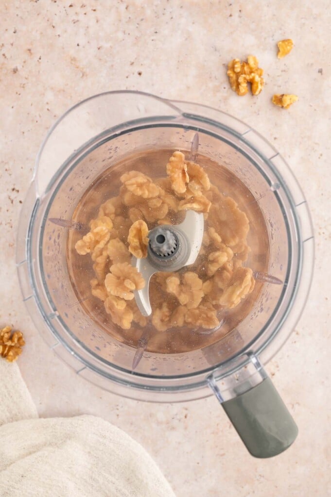 Soaked walnuts and water in a blender before blending.