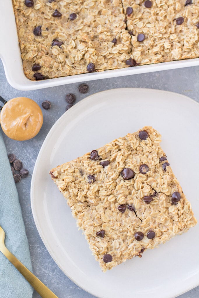 An overhead shot of Chocolate Peanut Butter Baked Oatmeal on a white plate with a dish of baked oatmeal off to the side