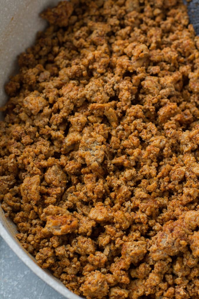 A close up of taco meat cooking in a white pan