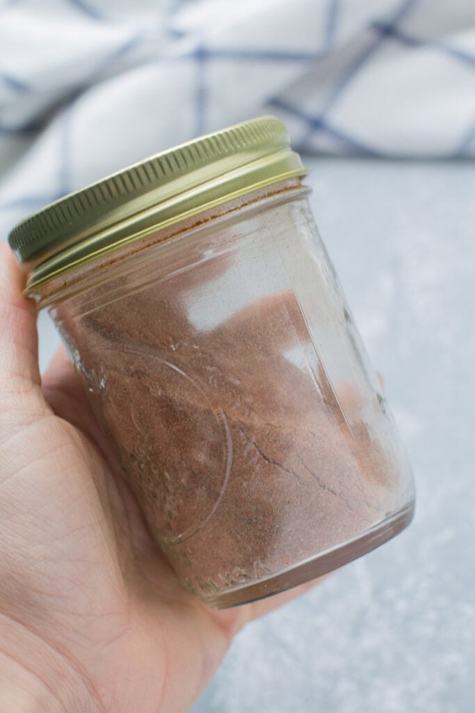 An image showing how to make healthy taco seasoning - a mason jar being shaken by hand
