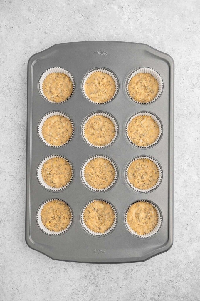 Unbaked lemon chia seed muffins in muffin tin.