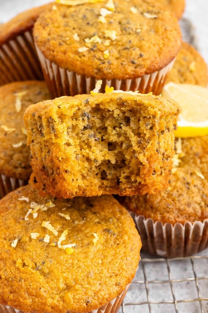 Close up view of freshly baked chia muffins, one has a bite taken out of it.