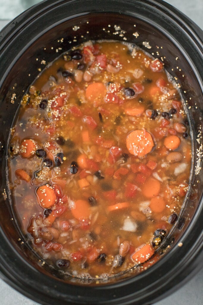 Chicken Quinoa Soup in the crockpot with broth being added