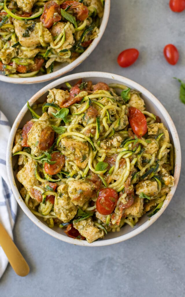 a close up image of Paleo Pesto Chicken Zucchini Noodles in a white bowl